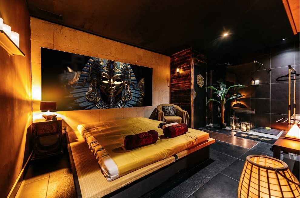 Luxurious bedroom with Egyptian art on the wall, ambient lighting, and modern decor.